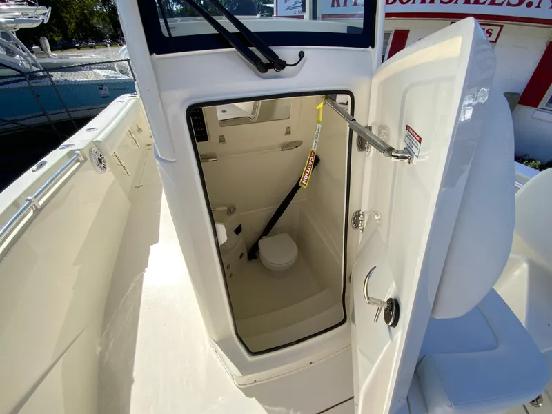 Slide: The Image of 2025 Cobia 240 Center Console boat with open cabin door showing interior. - 21