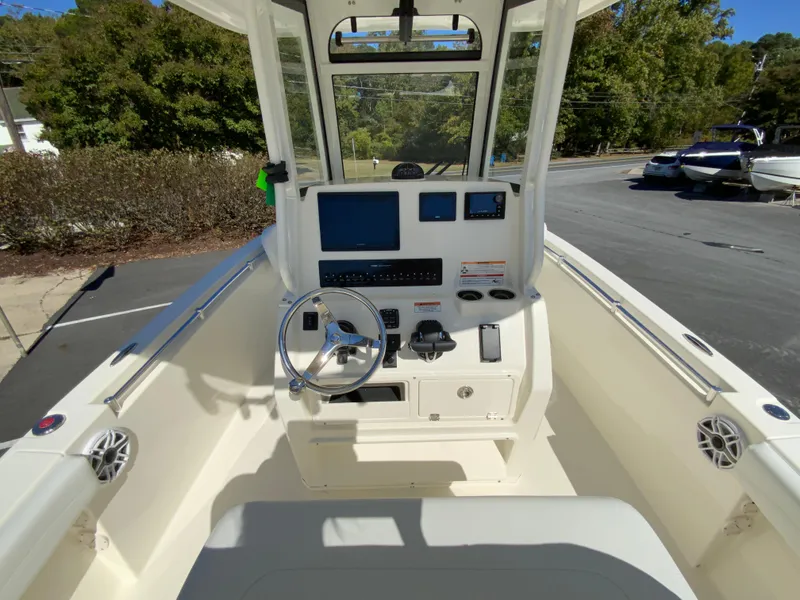 Slide: The Image of 2025 Cobia 240 Center Console boat interior with steering wheel and navigation equipment. - 25