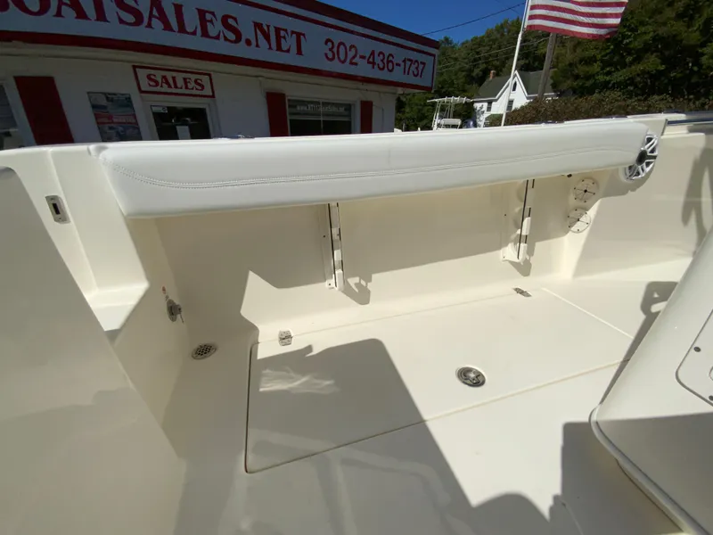 Slide: The Image of 2025 Cobia 240 Center Console boat interior with seating and storage, displayed at a sales location. - 36