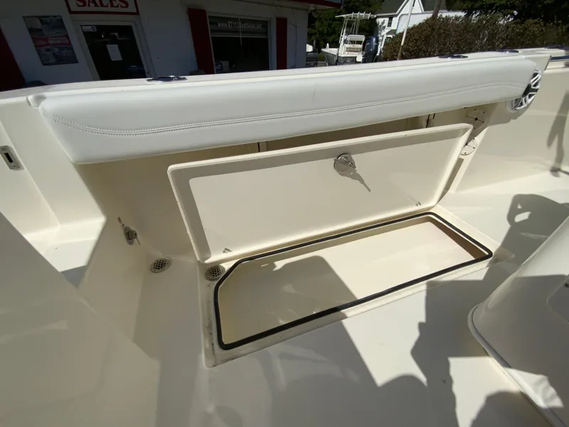 Slide: The Image of 2025 Cobia 240 Center Console boat storage compartment open in sunlight. - 37