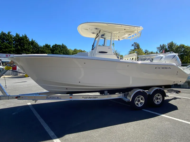 Slide: The Image of 2025 Cobia 240 Center Console boat on trailer, parked outdoors. - 5