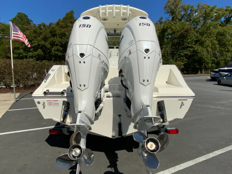 Slide: The Image of 2025 Cobia 240 Center Console with twin 150 horsepower engines, parked outdoors. - 8