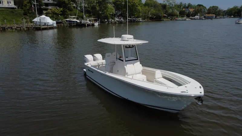 Slide: The Image of 2022 Regulator 25FS boat on calm water, featuring sleek design and twin engines. - 10