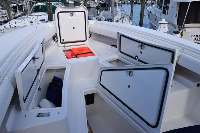 Slide: The Image of 2022 Regulator 25FS boat storage compartments open at marina. - 16