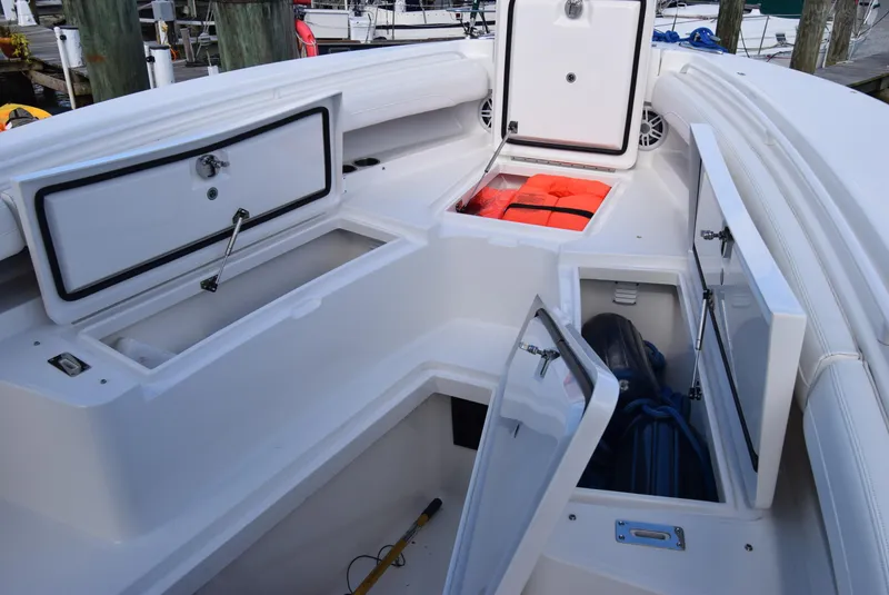 Slide: The Image of 2022 Regulator 25FS boat storage compartments with life jackets and equipment. - 17
