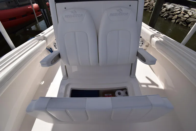 Slide: The Image of 2022 Regulator 25FS boat with white seating and storage compartment. - 25