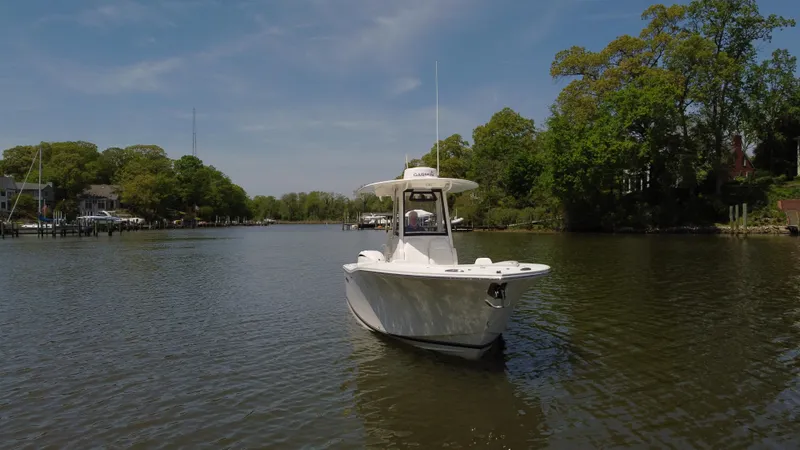 Slide: The Image of 2022 Regulator 25FS boat on a calm river, surrounded by lush greenery. - 3