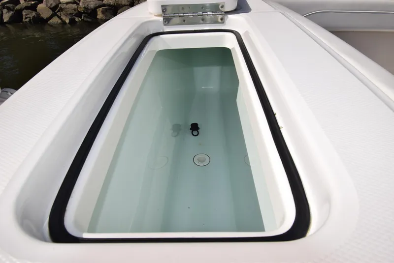 Slide: The Image of 2022 Regulator 25FS boat storage compartment with water, open lid view. - 36