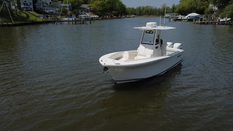 Slide: The Image of 2022 Regulator 25FS boat on a calm river near docks and houses. - 6