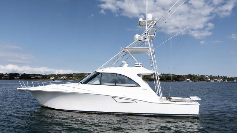 The Image of 2012 Cabo 44 HTX yacht on calm water under a partly cloudy sky. - 0