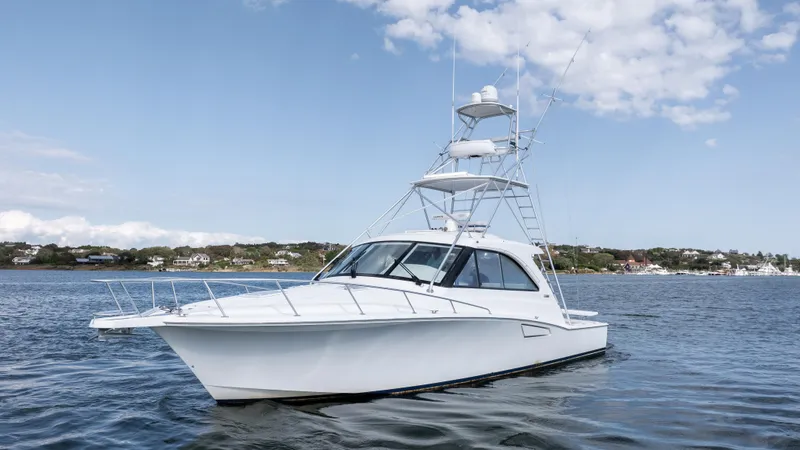 Slide: The Image of 2012 Cabo 44 HTX yacht on calm water under a blue sky. - 1