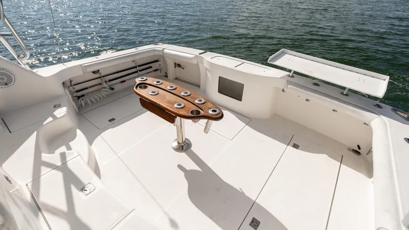 Slide: The Image of 2012 Cabo 44 HTX boat deck with fishing rod holders, on calm water. - 16