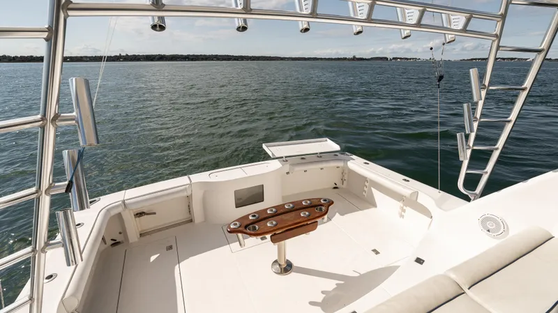 Slide: The Image of Cabo 44 HTX 2012 yacht deck with fishing rod holders, overlooking calm waters. - 18
