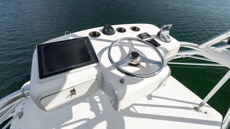 Slide: The Image of Helm of 2012 Cabo 44 HTX yacht with steering wheel and navigation equipment. - 24
