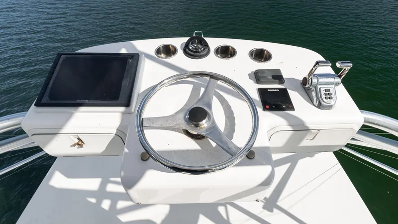 Slide: The Image of Helm of 2012 Cabo 44 HTX yacht with steering wheel and navigation controls. - 25