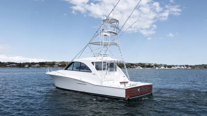 Slide: The Image of 2012 Cabo 44 HTX yacht on calm water under a clear sky. - 3