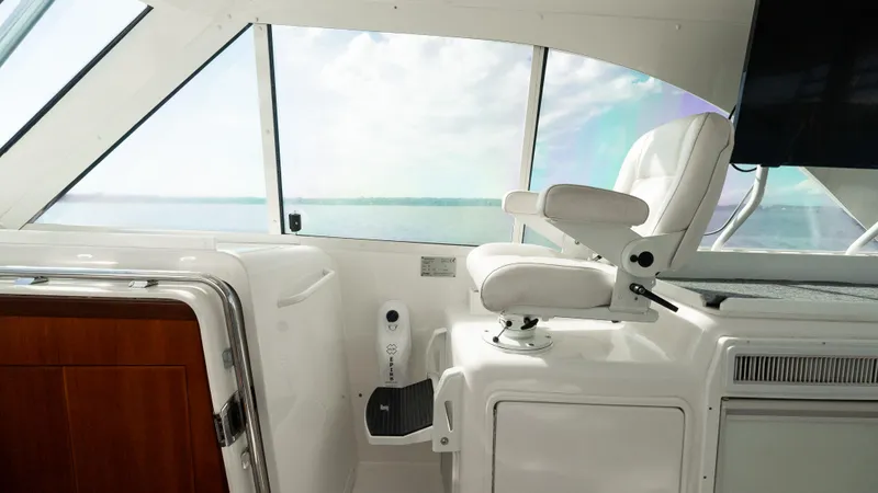 Slide: The Image of Helm area of 2012 Cabo 44 HTX yacht with white captain's chair and ocean view. - 34