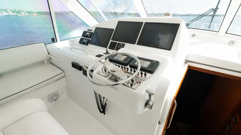 Slide: The Image of Helm of 2012 Cabo 44 HTX yacht with modern navigation equipment and steering wheel. - 35