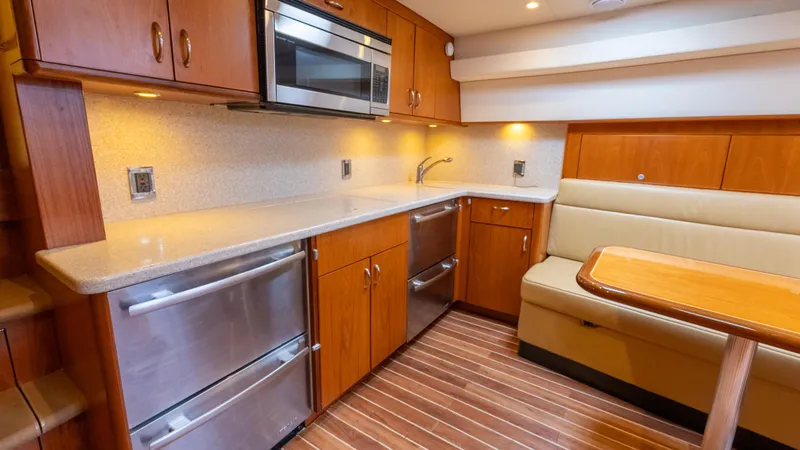 Slide: The Image of Luxurious 2012 Cabo 44 HTX yacht interior with modern kitchen and dining area. - 42