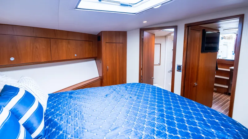 Slide: The Image of Luxurious cabin interior of 2012 Cabo 44 HTX yacht with blue bedding and wooden accents. - 46
