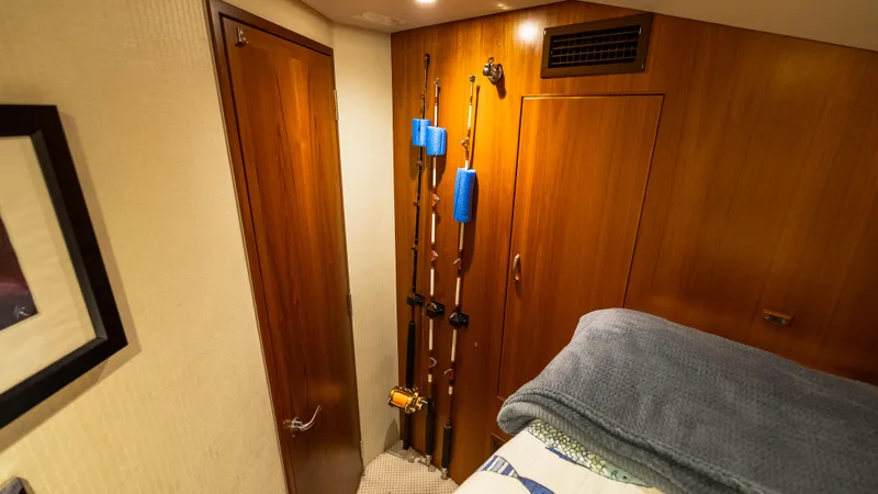 Slide: The Image of Interior of 2012 Cabo 44 HTX yacht with fishing rods and wooden cabinetry. - 47