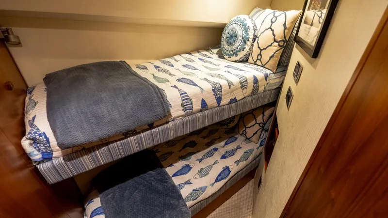Slide: The Image of Bunk beds with nautical-themed bedding in a 2012 Cabo 44 HTX yacht cabin. - 48