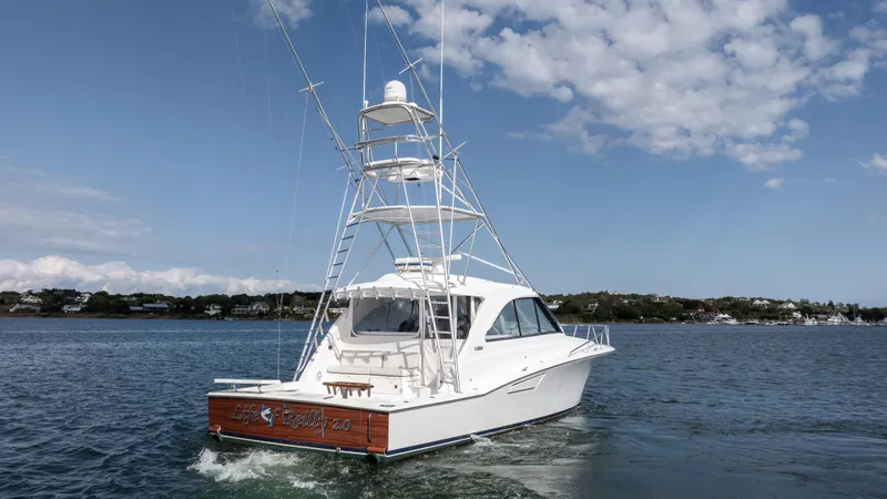 Slide: The Image of 2012 Cabo 44 HTX yacht cruising on a calm sea under a partly cloudy sky. - 5