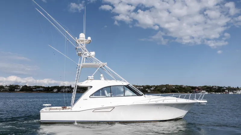 Slide: The Image of 2012 Cabo 44 HTX yacht on calm water under a blue sky. - 6