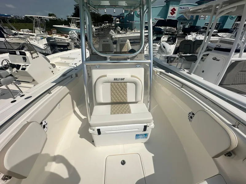 Slide: The Image of 2025 Bulls Bay 255 CC boat interior with seating and console, displayed at a marina. - 6