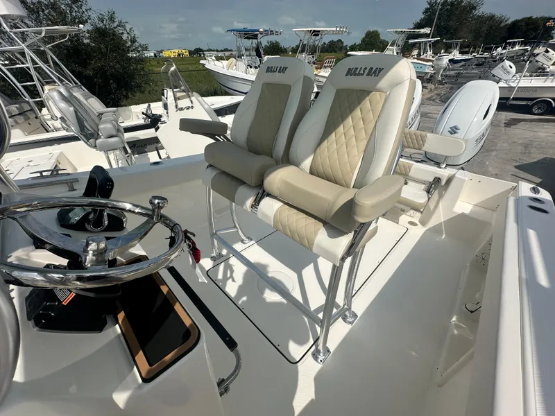 Slide: The Image of 2025 Bulls Bay 255 CC boat interior with dual cushioned seats and steering wheel. - 8