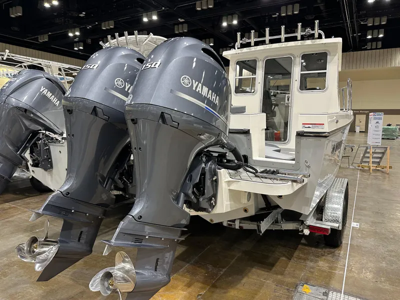 Slide: The Image of 2026 Defiance Admiral 250 EX boat with dual Yamaha 150 engines displayed indoors. - 3