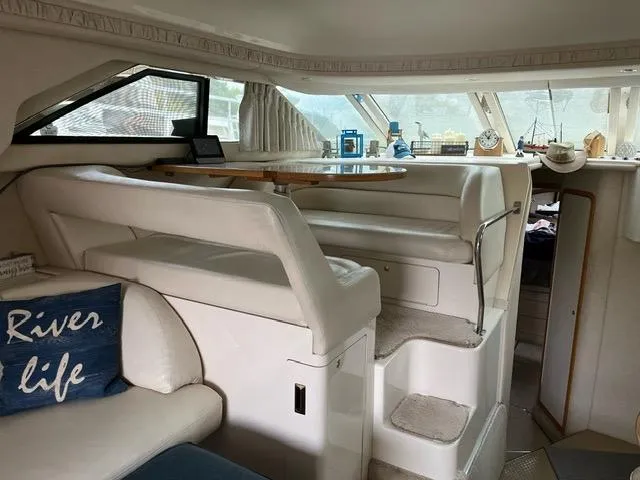 Slide: The Image of Interior of 1997 Sea Ray 400 Sedan Bridge yacht with plush seating and dining area. - 12