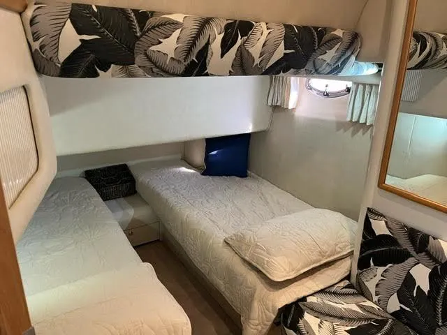 Slide: The Image of Interior cabin of 1997 Sea Ray 400 Sedan Bridge with bunk beds and tropical decor. - 16