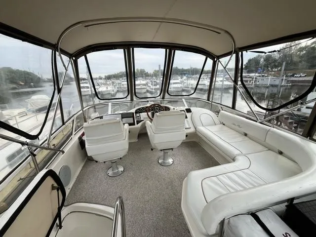 Slide: The Image of Interior of 1997 Sea Ray 400 Sedan Bridge yacht with white seating and panoramic windows. - 18