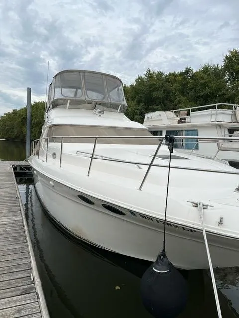 Slide: The Image of 1997 Sea Ray 400 Sedan Bridge docked, featuring sleek design and spacious deck. - 2