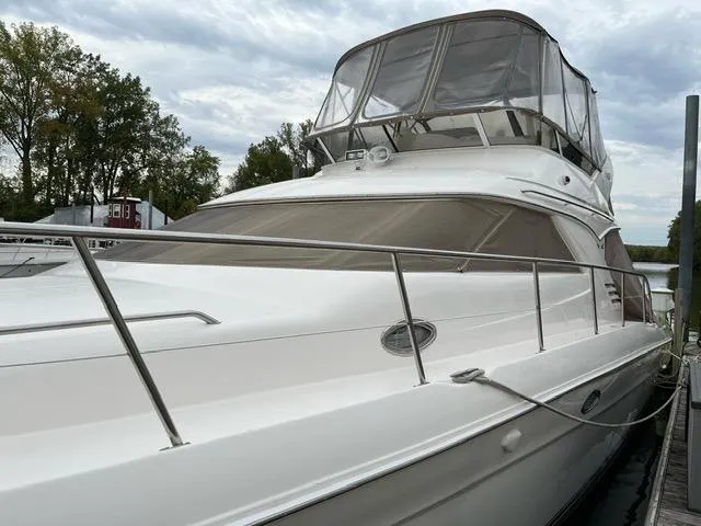 Slide: The Image of 1997 Sea Ray 400 Sedan Bridge yacht docked, featuring sleek design and spacious flybridge. - 20