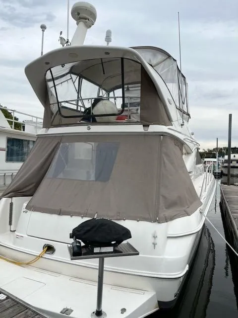 Slide: The Image of 1997 Sea Ray 400 Sedan Bridge docked, featuring covered upper deck and sleek design. - 3