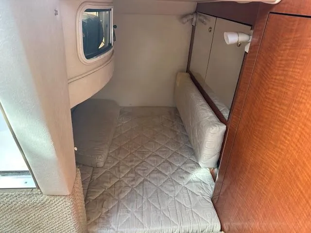 Slide: The Image of Interior cabin of 2003 Sea Ray 280 Sundancer with cushioned seating and wood paneling. - 17