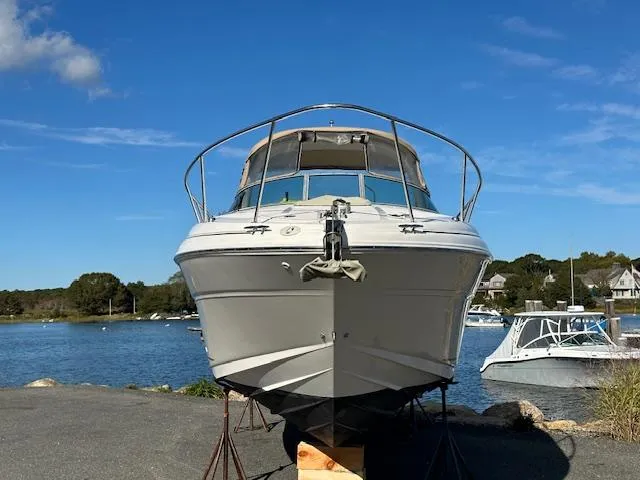 Slide: The Image of 2003 Sea Ray 280 Sundancer boat on dry dock by a scenic lake. - 2