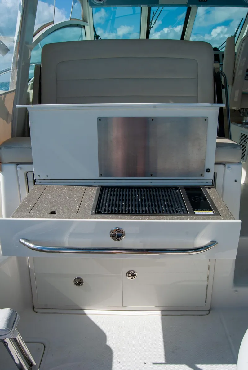 Slide: The Image of 2021 Boston Whaler 345 Conquest boat interior with grill and storage compartments. - 13