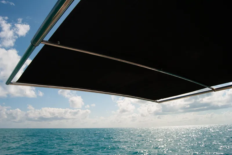 Slide: The Image of Boston Whaler 345 Conquest 2021 boat canopy over ocean with blue sky and clouds. - 15