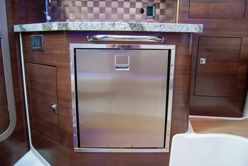 Slide: The Image of 2021 Boston Whaler 345 Conquest interior with stainless steel appliance and wood cabinetry. - 23