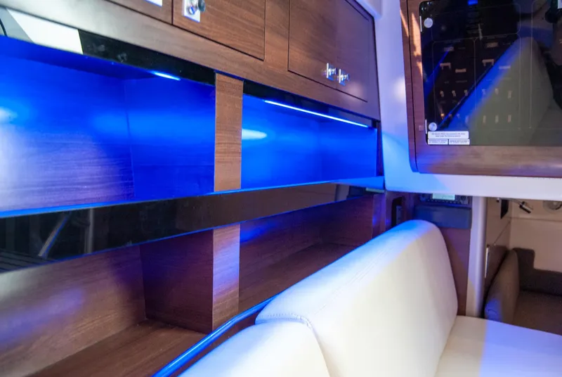 Slide: The Image of Interior of 2021 Boston Whaler 345 Conquest with blue LED lighting and wooden cabinetry. - 26