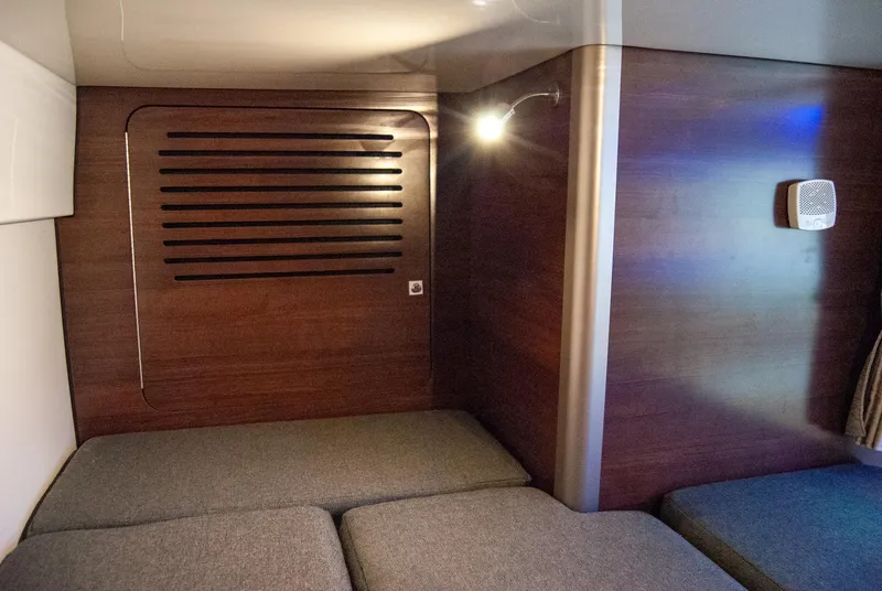 Slide: The Image of 2021 Boston Whaler 345 Conquest cabin interior with wooden paneling and cushioned seating. - 29