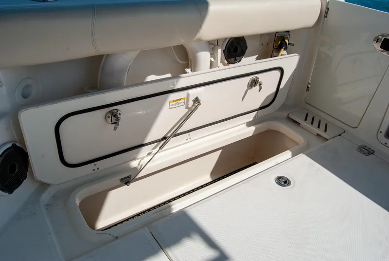 Slide: The Image of 2021 Boston Whaler 345 Conquest storage compartment, open and spacious, on a white deck. - 34