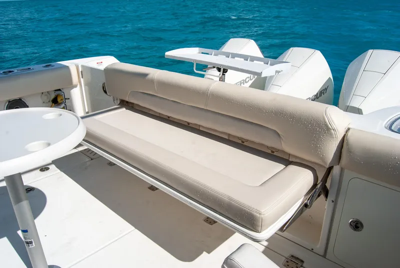 Slide: The Image of 2021 Boston Whaler 345 Conquest boat with cushioned seating and ocean backdrop. - 9