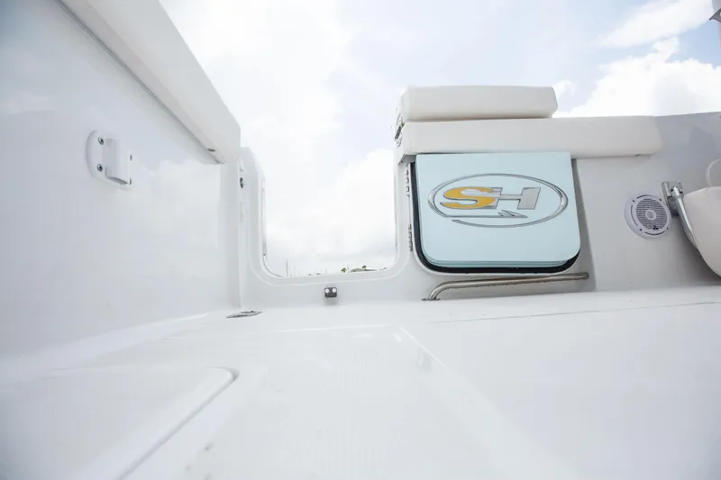 Slide: The Image of 2025 Sea Hunt Gamefish 25 boat interior with logo, white seating, and clear sky. - 11
