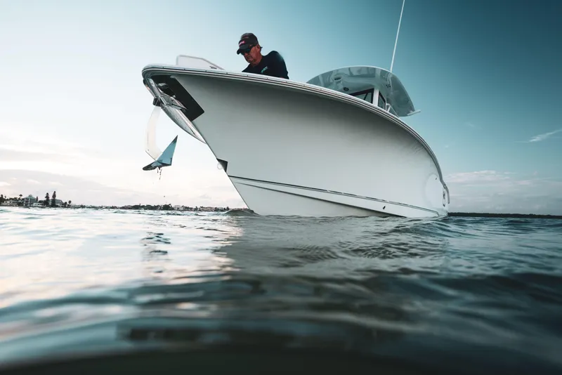 Slide: The Image of 2025 Sea Hunt Gamefish 25 boat on water, person onboard, clear sky background. - 6