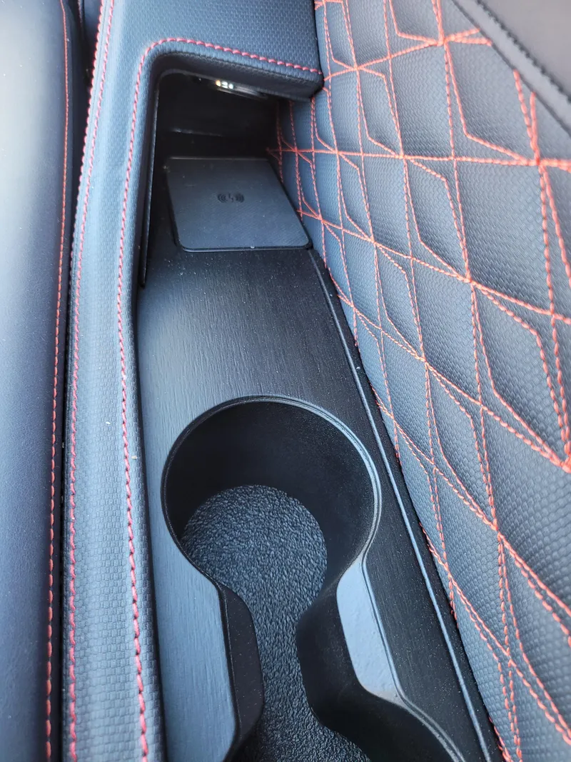Slide: The Image of 2025 Quest M-22RLS LIMITED interior cup holder with red-stitched upholstery. - 12
