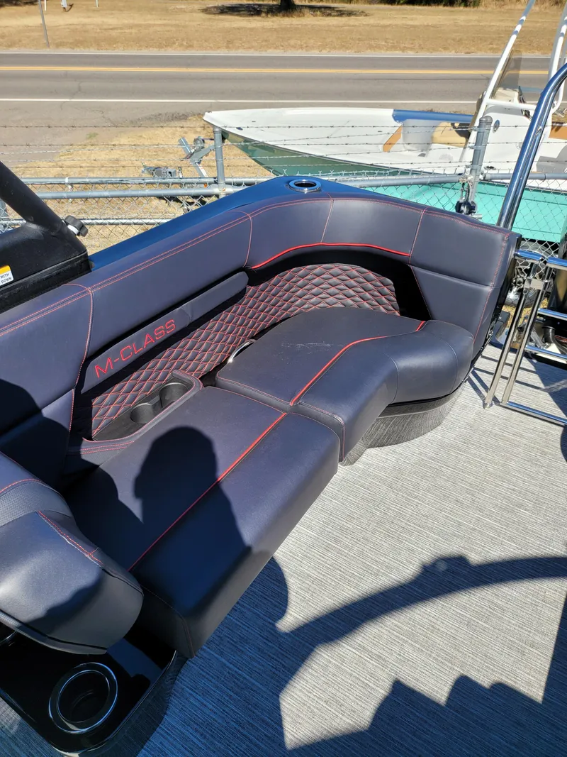 Slide: The Image of 2025 Quest M-22RLS LIMITED boat seating with black upholstery and red stitching. - 24
